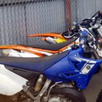 Multiple used dirt bikes for sale next to each other.